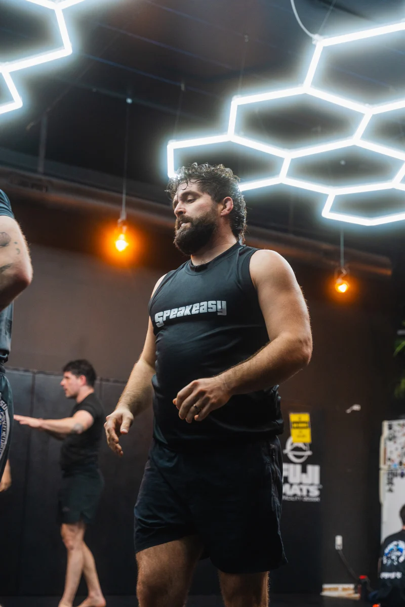 A coach leading adult Jiu Jitsu training at Speak Easy